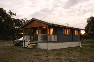 a small house with a car parked in a yard at Bretts Rest AZA in Kingscote