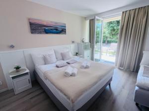 a bedroom with a bed with two towels on it at Szárszó Holiday Apartman in Balatonszárszó +18 photos