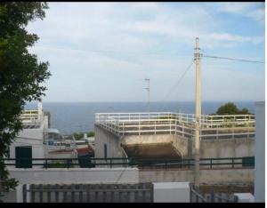 a view of a building with the ocean in the background at Villa Maria in Andrano