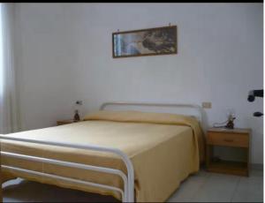 a bedroom with a bed and a picture on the wall at Villa Maria in Andrano