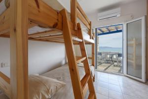 a bedroom with bunk beds and a view of the ocean at Villa Drios Semeli Paros in Drios