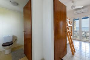 a bathroom with a toilet and a wooden door at Villa Drios Semeli Paros in Drios +65 photos