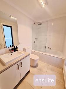 a bathroom with a sink and a tub and a toilet at Casey Green Estate 3 bedrooms Narre Warren home in Narre Warren