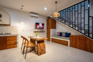a kitchen with a wooden table and a staircase at Villa The ARK - A by OriVista in Dalung