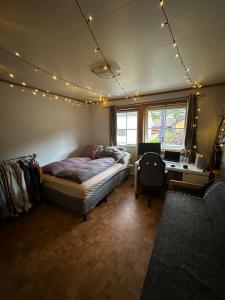1 dormitorio con cama, escritorio y luces en Rom i bofelleskap, en Sogndal