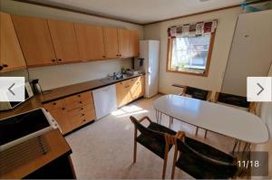 Una cocina con una mesa y un refrigerador blanco. en Rom i bofelleskap, en Sogndal