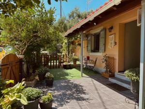 a yard with potted plants and a house at Matina's Village Getaway in Antipernoí