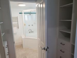 a bathroom with a shower and a sink at Kings Row Apartments in Caloundra +70 photos