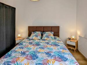 a bed with a colorful comforter in a bedroom at Bel appartement rénové avec WiFi et parking sécurisé à Vesoul - FR-1-583-473 in Vesoul