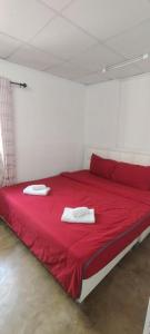 a red bed with two white towels on top of it at Double Room-C102 in Bangkok