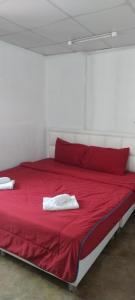 a red bed with two white towels on it at Double Room-C102 in Bangkok