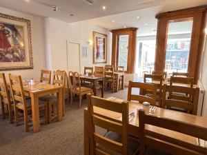 a dining room with wooden tables and chairs at The Royal Alexandra Hotel by Compass Hospitality in Blackpool