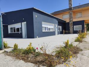 ein blaues Gebäude mit weißen Fenstern auf einem Parkplatz in der Unterkunft Lar de Yago - Apto Barreiros B in San Cosme de Barreiros