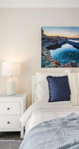 a bedroom with a white bed and a blue pillow at Summery 4BR Home by Mel Airport, CBD & Watergardens in Sydenham