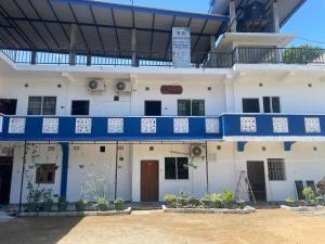 a large white building with a blue balcony at kk house in Kataragama