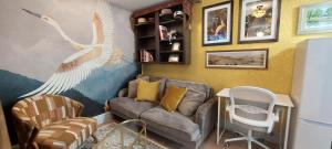 a living room with a couch and a peacock mural at Shakespeare's Writing Den On Riverside in Stratford-upon-Avon