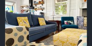 a living room with a blue couch and a chair at CERULEAN HOUSE - Iconic Renovated Period Home - Close to Everything in Bendigo