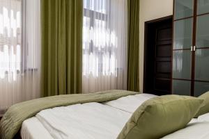 Un dormitorio con una cama con cortinas verdes y una ventana. en Nowe - PERŁA ŚRÓDMIEŚCIA & Free Parking 48m2, en Częstochowa