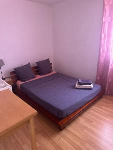 a bedroom with two beds with blue pillows and a table at apartment near metro Villejuif louis Aragon in Villejuif