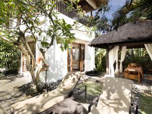 a group of chairs sitting outside of a house at Villa Canggu by Plataran in Canggu