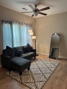 a living room with a couch and a mirror at The Coastal Comfort Suite in Gulf Shores