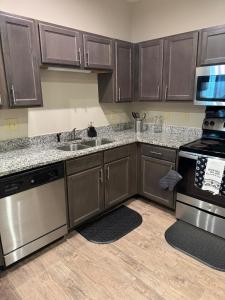 a kitchen with wooden cabinets and stainless steel appliances at The Coastal Comfort Suite in Gulf Shores