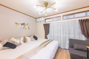 Dos camas en una habitación con ventana. en 新宿駅4分2駅から徒歩10分 最大3名 高速WiFi 1階のまるまる貸切部屋, en Tokio