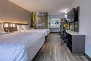 a hotel room with two beds and a desk at Clarion Pointe Decatur Downtown in Decatur