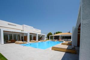 a swimming pool next to a building at Blue Summer Luxury Suites in Kourouta