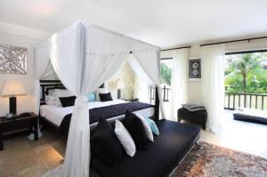 a bedroom with a bed with a canopy at Villa Arjuna in Tanah Lot