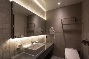 Un baño con lavabo, inodoro y espejo. en 21 Heritage Hotel, en Wonju