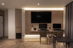 Una habitación con un escritorio con dos monitores de computadora en una pared. en 21 Heritage Hotel, en Wonju