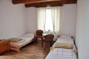 a room with three beds and a table and chairs at Przystanek Bieszczad in Lutowiska