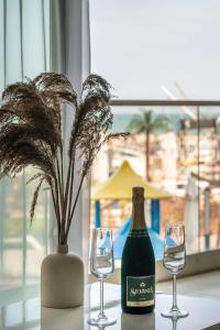 a bottle of wine and two glasses on a table at Ozone Apartment Spa & Pool Beach Resort in Mamaia