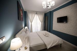 a bedroom with a white bed and a window at Ozone Apartment Spa & Pool Beach Resort in Mamaia +51 photos