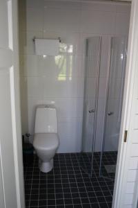 La salle de bains est pourvue d'une douche et de toilettes blanches. dans l'établissement Köpmans, à Nauvo