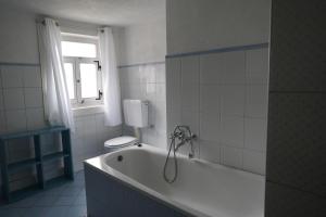 a bathroom with a tub with a toilet and a window at Weiherhof in Ehrenberg +54 photos