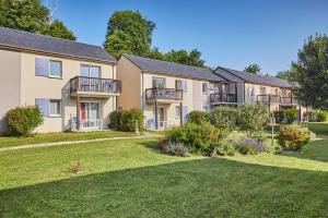 ein Apartmenthaus mit Balkon und Hof in der Unterkunft Résidence Odalys Le Hameau du Lac in Rignac