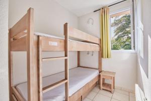 Etagenbett in einem Zimmer mit Fenster in der Unterkunft Résidence Odalys Le Hameau du Lac in Rignac + 37 Fotos