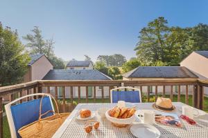einen Tisch mit Essen und Brot auf einer Terrasse in der Unterkunft Résidence Odalys Le Hameau du Lac in Rignac
