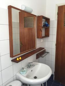 a bathroom with a sink and a mirror and a toilet at Popy Apartments in Ierapetra