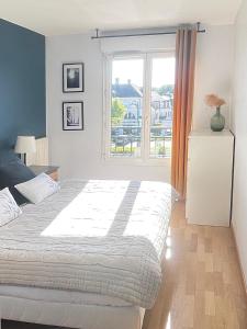 ein Schlafzimmer mit großem Bett und Fenster in der Unterkunft Luxury Appartement Disneyland in Magny-le-Hongre