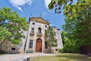 stary kamienny budynek z drewnianymi drzwiami w obiekcie Villa Bertagnolli - Locanda Del Bel Sorriso w Trydencie