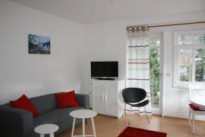a living room with a couch and a tv at Gästehaus Villa Lina in Bad Herrenalb