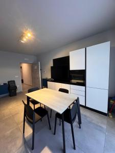 Una cocina con una mesa y sillas de madera en una habitación. en Residence La Vela, en Margherita di Savoia