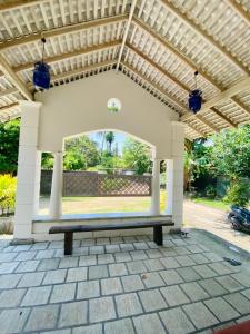 eine Terrasse mit einer Bank unter einer Pergola in der Unterkunft Silva's Place, Peaceful Budget Stay in Balapitiya in Balapitiya + 14 Fotos