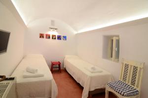 a small room with two beds and a chair at Rodamia Traditional Cottage in Kythira