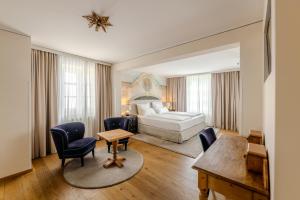 pokój hotelowy z łóżkiem, stołem i krzesłami w obiekcie Boutiquehotel Amadeus w mieście Salzburg