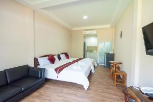 a hotel room with a bed and a couch at Baansuan Aokhai Beach Resort in Mae Pim