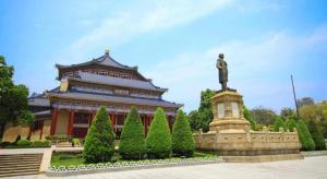 ein großes Gebäude mit einer Statue davor in der Unterkunft Nan Guo Hotel in Guangzhou